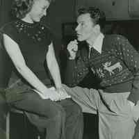 Black-and-white photo of Frank Sinatra, reindeer sweater, & Jane Powell in a posed radio studio 