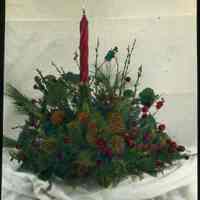 Lantern slide, color, of a Christmas centerpiece with pine cones & candle, used for promotional display in Hoboken, no date, ca. 1920.