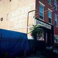 Color photo of sign for Mud Hut painted on the south wall of 416 Bloomfield St., Hoboken, Sept., 1-5, 2001.