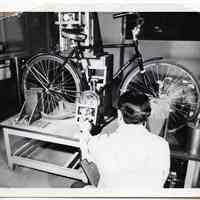 B+W photo of bicycle petal load test as per B.M.A. 6 at United States Testing Co. facility, Hoboken, N.d., ca. 1979-1990.