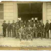 Sepia-tone group photo of Keuffel & Esser Co. employees posed outside newly opened west plant on Adams St. near 3rd St. for K&E 40th anniversary, Hoboken, July 20, 1907.