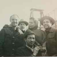 B+W group photo of "On the Waterfront" filming in Hoboken: a woman & 5 men on the piers, Hoboken, no date, ca. late 1953-early 1954.