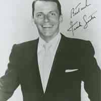 Black-and-white photo of Frank Sinatra in dark suit and tie,signed and inscribed in image, no place, no date, ca. 1950.