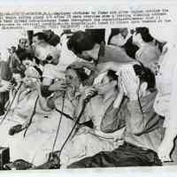 B+W photo of Maxwell House Coffee plant employees getting first aid on street after exposure to gas fumes, Hoboken, May 8, 1957.