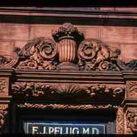          Color slide of close-up view of portico pediment and transom window signage reading 