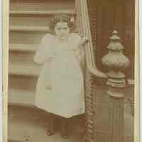 Cabinet photo of unidentified small girl posing at the bottom of front stoop, no place, no date. ca. 1893-95.