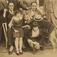         detail center: Stack Brothers(?); two girls; dog with coat initialed SK
   