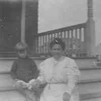 B+W negative image of an unidentified woman and young girl seated on porch steps, no place, no date, ca. 190