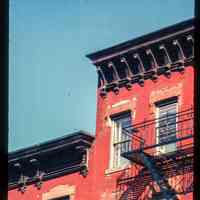 Color slide of detail view of fire escape, cornices, brackets, and window heads on two unidentified buildings