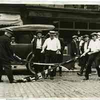 B+W photo of men tearing up an IWW flag in front of their headquarters, 316 River St. Hoboken, ca. July 28-30, 1923.