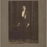 Sepia-tone photo of young man in formal wear in photographer