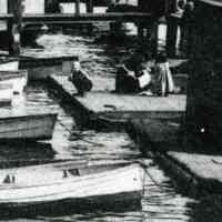          detail lower right: woman and two children on dock
   