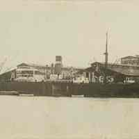 Sepia-tone photo of an unidentified Holland America Line ship at Albers Brothers Milling Co. pier in Seattle or Tacoma, WA, n.d., ca. 1900-1920.