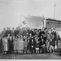 B+W group photo of men, women & children taken on Bethlehem Steel shipyard pier, Hoboken, n.d., ca. 1940-1943.