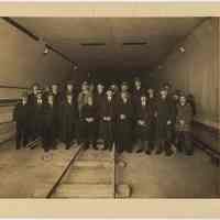 Sepia-tone group photo of tunnel commission members & other staff inspecting Holland Tunnel tile, lighting & railing samples, N.Y., Feb. 10, 1925.
