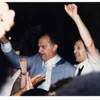 Color photo of mayoral candidate Tom Vezzetti in front of City Hall with supporters on election night, Hoboken, [June 11, 1985].