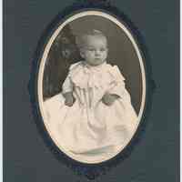 Sepia-tone photo portrait of baby posed in photographer