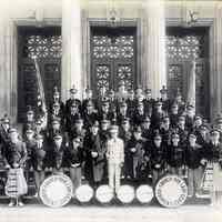 Sepia-tone photo of OLG Fife, Drum & Bugle Corps posed on steps at Demarest High School main entrance, Garden St., Hoboken, n.d., ca. 1935-1945.