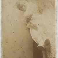 Sepia-tone photo of an unidentified baby, ca. 1-2 years old, posed asleep on a chaise in a studio, Hoboken, no date, ca. 1890-1900.