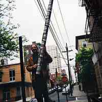 Three digital images: Artist Robert Burczy installing 