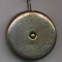          side with custom engraving: Anchor Packing Co.; stop button at center
   