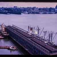 Color slide of aerial view from River & 3rd looking E at Pier B with the New York City skyline across the Hudson River