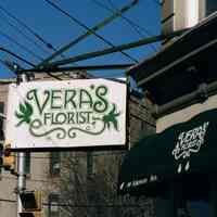 Color photo of hanging sign for Vera