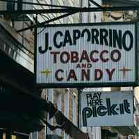 Color photo of hanging sign for J. Caporrino, Tobacco and Candy, 528 Adams St., Hoboken, Jan. 3 & 4, 2002.