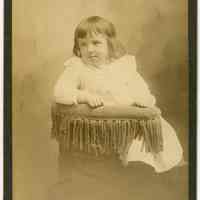 Cabinet photo of a young child posed on chair in photographer