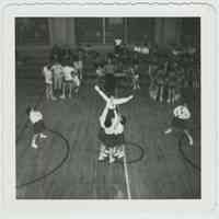 B+W photo of cheerleaders performing a routine in a school gym, Hoboken, no date, ca. 1955.