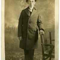 Sepia-tone photo of man in overcoat & hat posed in studio, Hoboken, n.d., ca. 1904-1918.