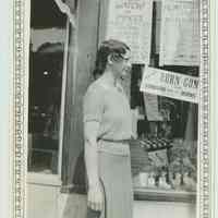 B+W photo of a woman posed in front of the exterior of Baron