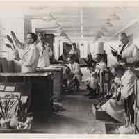 B+W photo of U.S.D.A. Quarantine Building interior with several inspectors at work, River St., Hoboken, April 1954.