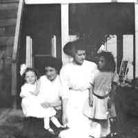 B+W negative image of two unidentified young woman and 2 young girls in a backyard, no place, no date, ca. 190