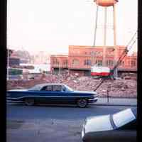 Color slide of a street, water tower and a demolition site.