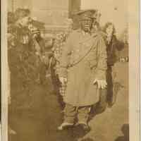 sepia-tone photo of Joseph Yaccarino as "Joe Biggie" in blackface minstrel make-up & costume participating in street event, Hoboken, 1937.
