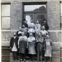          15 Newark exterior, 9 to 17 Saint Francis St.; men with work aprons outside
   
