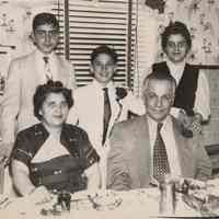 B+W photo of Joseph "Biggie" Yaccarino and family posed at a kitchen dining table, Hoboken, no date, circa 1955-60.