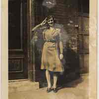 Sepia-toned photo of a woman in military uniform outside 108 Tenth St., Hoboken, no date, probably 1941-1945.