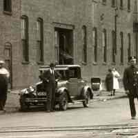          detail left: street sign on buildings; police; cars
   