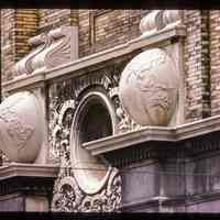 Color slide of detail view of portico keystone, oculi window, pilasters, and capitals of Public School No. 7 building at 80 Park on the SW corner with Newark