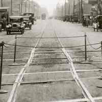          detail center: stanchions & ropes at track crossing; gasoline station right
   