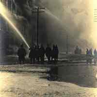 Sepia-tone photo of exterior view of a fire at John Schmalz
