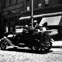 B+W photo of an automobile, jitney autobus, on Newark St. near Hudson St., 1915.