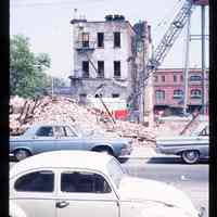 Color slide of cars in front of a demolished building.