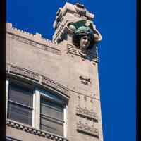 Color slide of detail view of roofline figurine and decorative tiles of the Terminal Building at 70 Hudson Street on the NW corner of Hudson Place