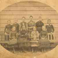 Sepia-tone group photo of the class 1876 of the Martha Institute posing outside the school, Hoboken, 1876.