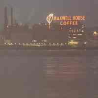 Color photo of Maxwell House Coffee plant & neon sign at night from Hudson River, Hoboken, n.d., ca. 1960-1980.