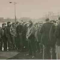 B+W candid photo of "On the Waterfront" filming in Hoboken: Marlon Brando is at center with large group, Hoboken, n.d., ca. late 1953-early 1954.