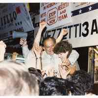 Color photo of mayoral candidate Tom Vezzetti with supporters in front of his campaign headquarters on election night, Hoboken, [June 11, 1985].